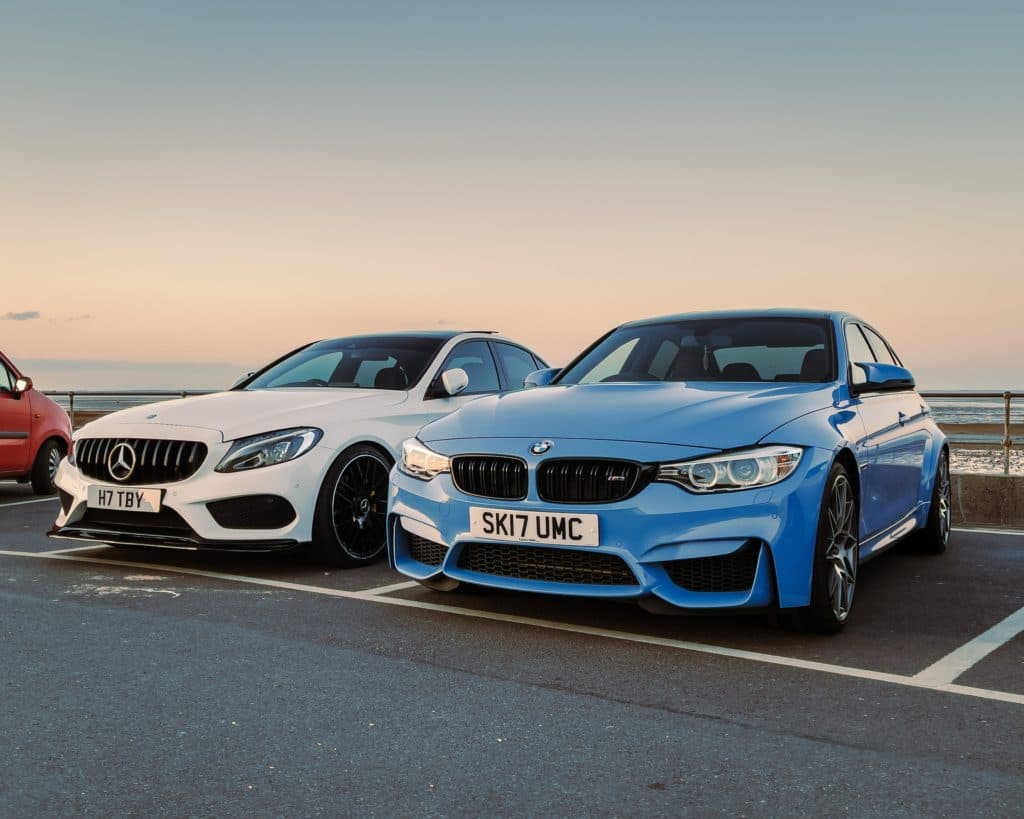 One silver car and one blue car side by side